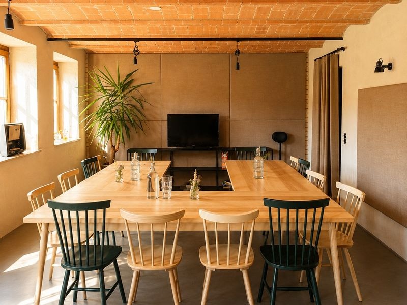 Der Stall als Arbeitsraum: Tische in U-Form, Ziegelkappendecke und Tageslicht