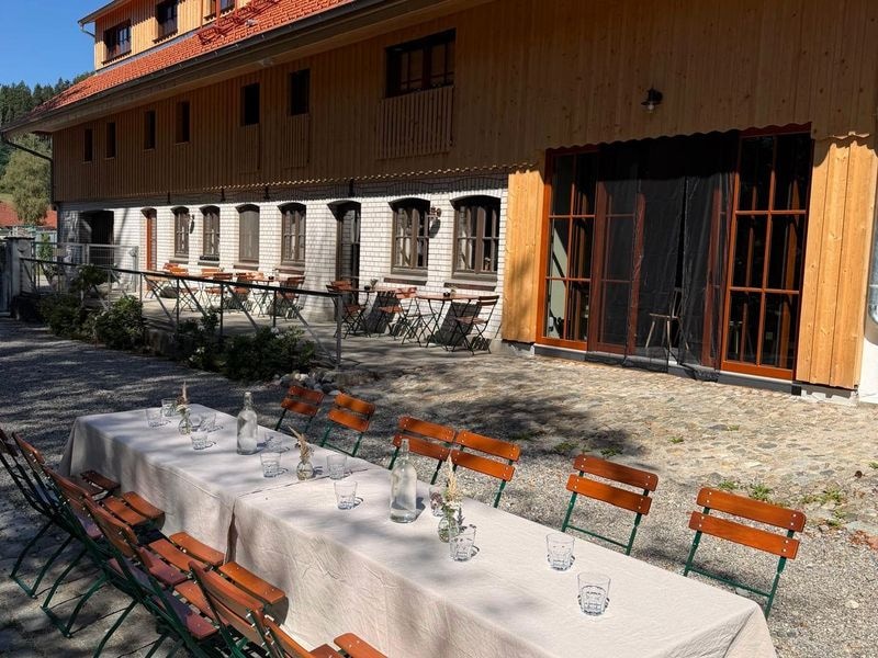 Gedeckte Tafeln vor der Tenne, Sonne auf der Fassade