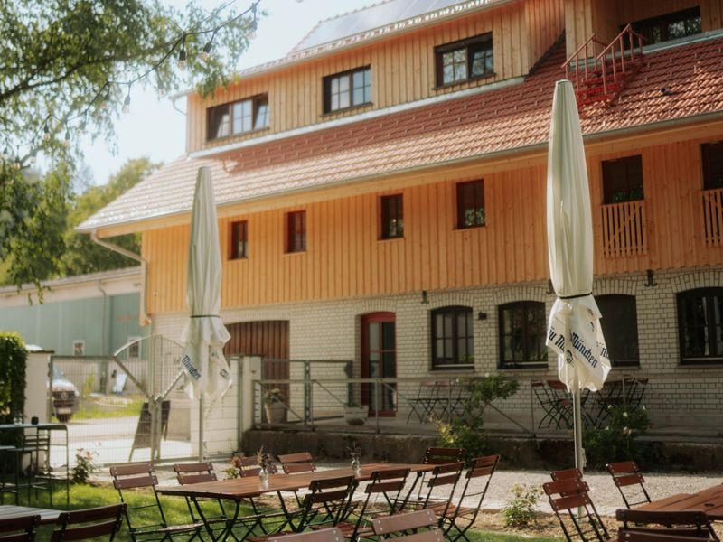 Biergarten mit Lichterkette vor dem Haupthaus