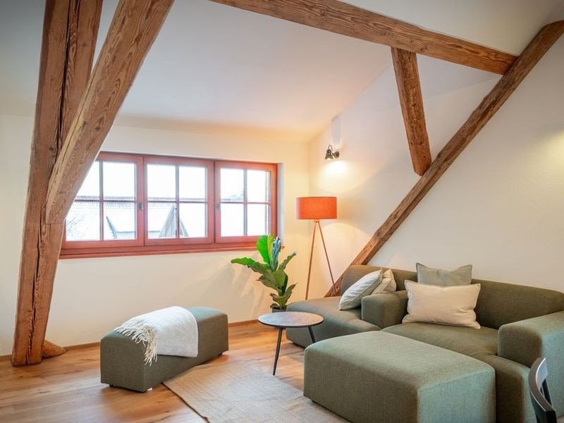 Wohnzimmer im Apartment Gipfelstürmer mit Sofa unter altem Gebälk