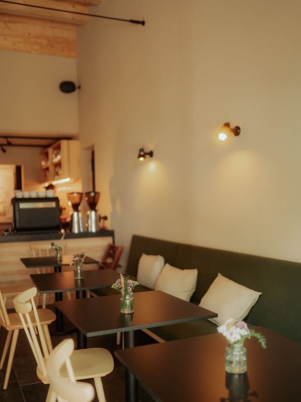 Der Bistroraum mit Sitzbank, Tischen und Kaffeetheke
