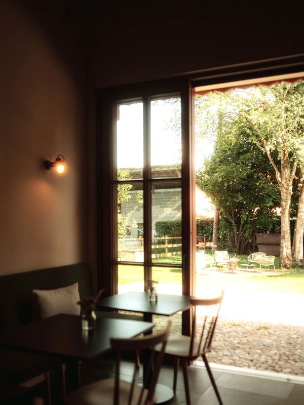 Bistrotisch mit Blick durch die offene Tür in den Hofgarten