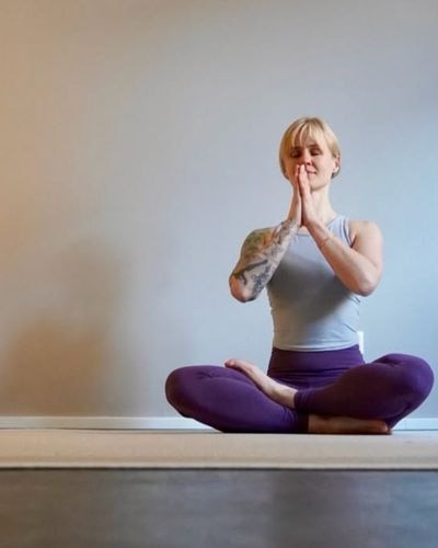 Yogalehrerin Anne Böse im Sitz mit geschlossenen Augen und Händen vor der Brust