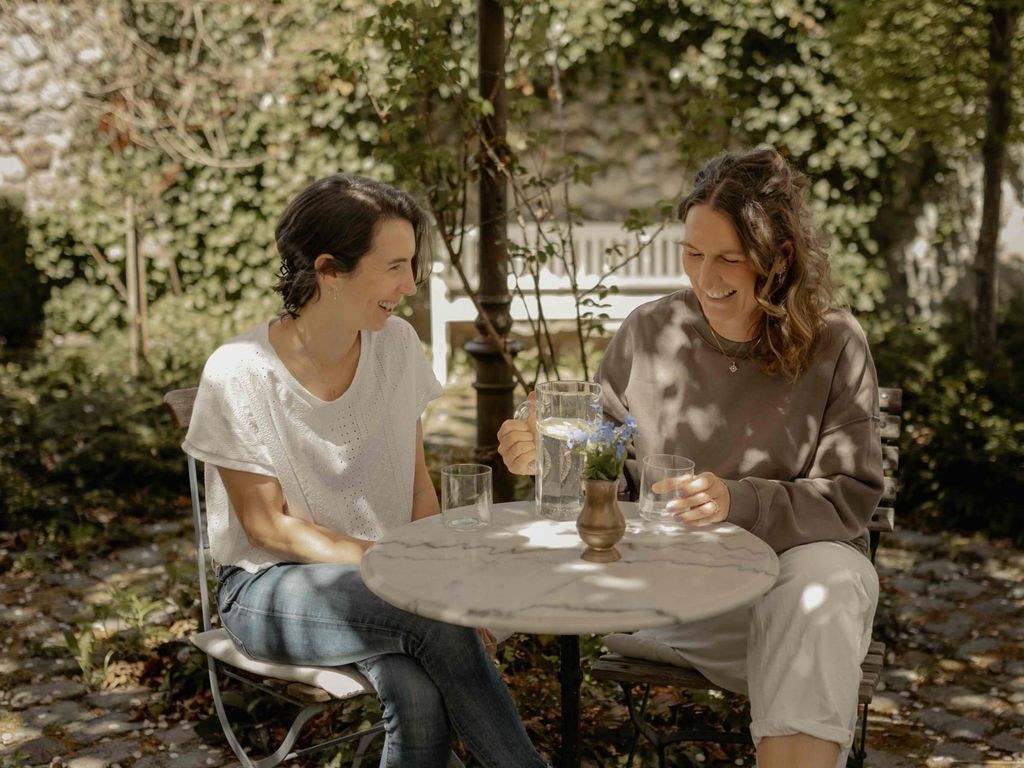 Die Gastgeberinnen im Garten unter blühenden Kirschbäumen