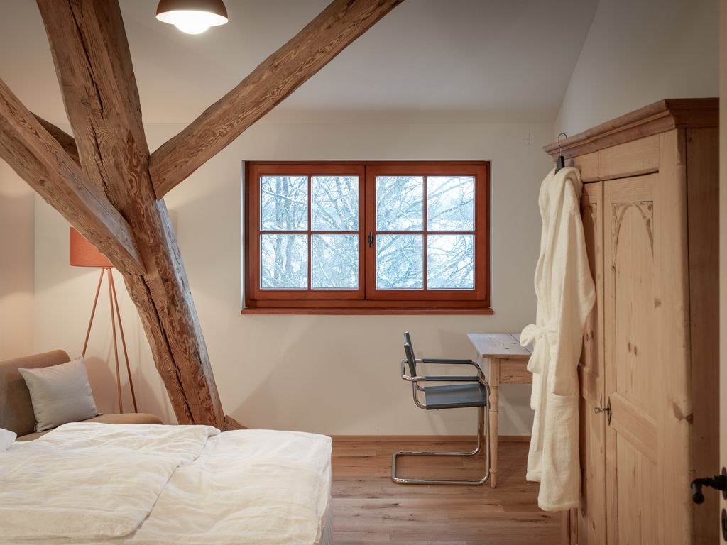 Schlafzimmer mit historischem Dachstuhl in einem Apartment im tobel1853